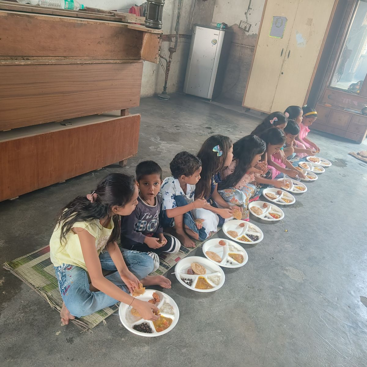 Children enjoying prasad during Kanya Pujan at Shiv Parmarth Dham